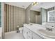 Full bathroom featuring dual sinks, a mirror, a tiled floor and striped wallpaper at 1510 Summer Lake Ter, Loganville, GA 30052