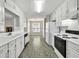 Bright kitchen features white cabinets, appliances, and tile backsplash at 1510 Summer Lake Ter, Loganville, GA 30052