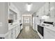 Bright kitchen features white cabinets, appliances, and tile backsplash at 1510 Summer Lake Ter, Loganville, GA 30052