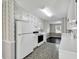 Well-lit kitchen with white cabinetry, a black appliance suite, and decorative wallpaper at 1510 Summer Lake Ter, Loganville, GA 30052