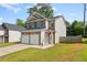 Well-maintained two-story home featuring a two-car garage, lush lawn, and classic siding details at 154 Stephens Mill Dr, Dallas, GA 30157