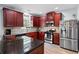 Well-equipped kitchen features stainless steel appliances, granite countertops, and cherry cabinets at 154 Stephens Mill Dr, Dallas, GA 30157