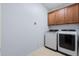 Modern laundry room with wood cabinets and newer washer and dryer appliances at 2245 Long Bow Chase, Kennesaw, GA 30144