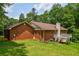 View of the home's backyard featuring a wooden deck, brick exterior, and lush green lawn at 3223 Heritage Way, Buford, GA 30519