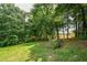Spacious backyard with lush green grass and mature trees, perfect for outdoor activities at 3223 Heritage Way, Buford, GA 30519