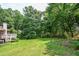 Spacious backyard with lush green grass and mature trees, perfect for outdoor activities at 3223 Heritage Way, Buford, GA 30519