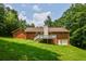 View of the home's backyard featuring a wooden deck, brick exterior, and lush green lawn at 3223 Heritage Way, Buford, GA 30519