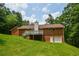 View of the home's backyard featuring a wooden deck, brick exterior, and lush green lawn at 3223 Heritage Way, Buford, GA 30519