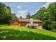 View of the home's backyard featuring a wooden deck, brick exterior, and lush green lawn at 3223 Heritage Way, Buford, GA 30519