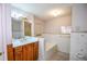 Well-lit bathroom with a large mirror, vanity, and soaking tub at 3223 Heritage Way, Buford, GA 30519