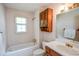 This bathroom features a shower and bathtub combo, wooden cabinets, and a bright mirror at 3223 Heritage Way, Buford, GA 30519