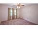 This bedroom offers neutral walls, a ceiling fan, and window with curtains for a cozy space at 3223 Heritage Way, Buford, GA 30519