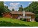 Exterior view of the brick house, featuring a wooden deck and lush green yard at 3223 Heritage Way, Buford, GA 30519