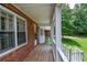 Inviting front porch with wooden floor, white railing, and peaceful greenery at 3223 Heritage Way, Buford, GA 30519
