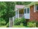 Inviting front porch with white railing, brick walls, and lush landscaping at 3223 Heritage Way, Buford, GA 30519