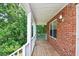Inviting front porch with wooden floor, white railing, and peaceful greenery at 3223 Heritage Way, Buford, GA 30519