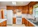 Spacious kitchen features matching appliances, wood cabinets and breakfast bar at 3223 Heritage Way, Buford, GA 30519