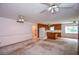 Large living room featuring an open kitchen with wood cabinets and multiple ceiling fans at 3223 Heritage Way, Buford, GA 30519