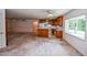 Spacious living room featuring an open kitchen with wood cabinets and a bright window view at 3223 Heritage Way, Buford, GA 30519