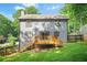 View of the home's rear facade with a large deck overlooking the grassy backyard and wooded area at 998 Pointer Rdg, Tucker, GA 30084