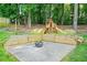 Landscaped backyard with wood retaining walls, a concrete patio, and a custom-built wooden playset with a slide at 998 Pointer Rdg, Tucker, GA 30084
