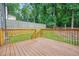 Spacious backyard deck with wood railing and steps leading to a lawn and privacy fence at 998 Pointer Rdg, Tucker, GA 30084