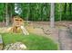 Wooden playset and a swing with a slide for outdoor enjoyment in a green, tree-filled backyard at 998 Pointer Rdg, Tucker, GA 30084