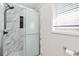Modern bathroom with glass enclosed shower, marble wall tile and window at 998 Pointer Rdg, Tucker, GA 30084