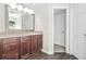 Bathroom features dark wood cabinets, laminate flooring, large mirror and modern lighting at 998 Pointer Rdg, Tucker, GA 30084