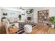 Inviting living room with hardwood floors, a stone fireplace, a ceiling fan, and built-in bookshelves at 998 Pointer Rdg, Tucker, GA 30084