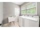 Laundry room featuring a washer, dryer, utility sink and tile floors at 1515 Lockridge Dr, Cumming, GA 30041