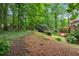 View of wooden deck and pergola in a lush backyard with mature trees and landscaping at 1548 Valley Reserve Court, Kennesaw, GA 30152