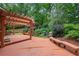 Large wooden deck with pergola overlooking a beautifully landscaped yard and waterfall feature at 1548 Valley Reserve Court, Kennesaw, GA 30152