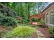 Lush backyard featuring a stone pathway leading to a pergola-covered deck and mature landscaping at 1548 Valley Reserve Court, Kennesaw, GA 30152
