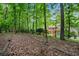 View of mature trees surrounding a backyard featuring a wooden pergola and brick architecture at 1548 Valley Reserve Court, Kennesaw, GA 30152