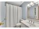 A bathroom with a shower with curtain, a vanity with sink, and a modern mirror at 1548 Valley Reserve Court, Kennesaw, GA 30152