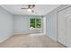 A cozy bedroom with a ceiling fan and large window overlooking a wooded backyard at 1548 Valley Reserve Court, Kennesaw, GA 30152