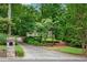 Long, curved driveway leading to a home, framed by mature trees and landscaped gardens at 1548 Valley Reserve Court, Kennesaw, GA 30152