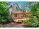 Rear exterior of a home featuring a wooden deck and lush, mature landscaping at 1548 Valley Reserve Court, Kennesaw, GA 30152
