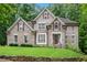 Charming brick home featuring a manicured lawn, mature trees, and a welcoming facade at 1548 Valley Reserve Court, Kennesaw, GA 30152