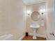 Elegant powder room features a pedestal sink, hardwood floors and decorative wallpaper at 1548 Valley Reserve Court, Kennesaw, GA 30152