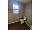 Bathroom view features a standard toilet, neutral wall color and wood-look laminate flooring at 170 Inverness Trce, Riverdale, GA 30274