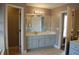 A bathroom featuring a gray vanity with a mirror, storage, and a tile floor with doorways to other rooms at 3145 Sweet Basil Ln, Loganville, GA 30052