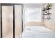 Relaxing bathroom with a soaking tub, separate shower, and a window that provides natural light and ventilation at 3145 Sweet Basil Ln, Loganville, GA 30052