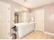 Well-lit bathroom with double doors, double sink vanity, and tiled floors, ideal for getting ready in the morning at 3145 Sweet Basil Ln, Loganville, GA 30052
