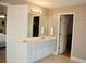 A bathroom featuring a white vanity with double sinks, storage, and views of closet and another room at 3145 Sweet Basil Ln, Loganville, GA 30052