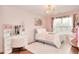 Charming bedroom with a desk, white rug, pink accents, and ample lighting at 3145 Sweet Basil Ln, Loganville, GA 30052