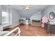 Spacious bedroom with slanted ceiling, hardwood floors, seating area and min-fridge at 3145 Sweet Basil Ln, Loganville, GA 30052