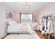 Cozy bedroom with pink accents, floral decor, and hardwood flooring at 3145 Sweet Basil Ln, Loganville, GA 30052