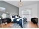 Stylish bedroom with a white metal bed, desk, hardwood floors, and a cozy atmosphere at 3145 Sweet Basil Ln, Loganville, GA 30052